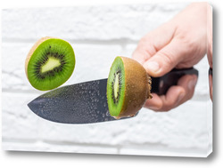   Картина Floating knife slicing trough kiwi fruit.