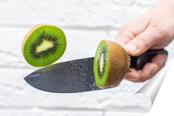   Постер Floating knife slicing trough kiwi fruit.