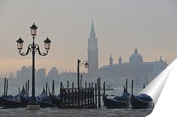  Гондольер на берегу канала в Венеции ждет клиента